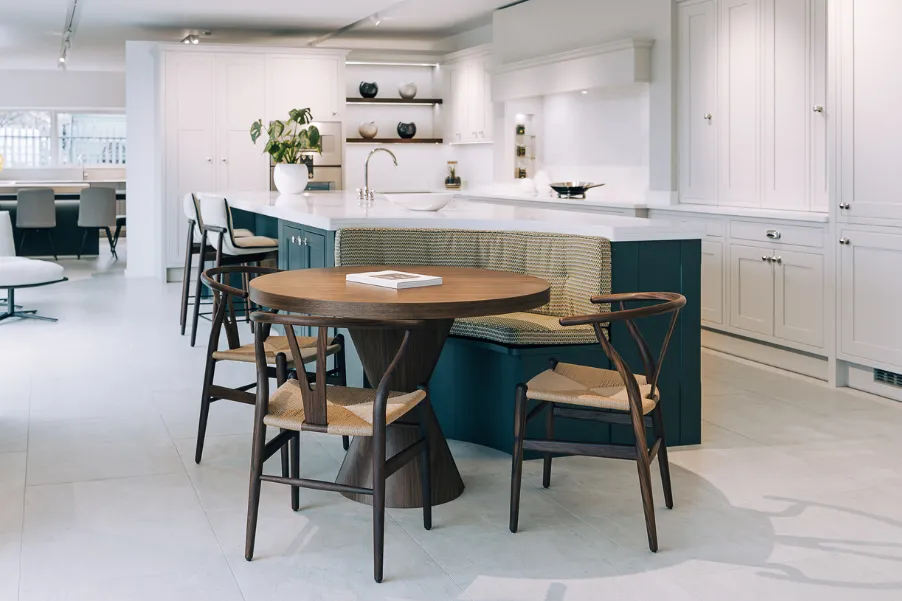 Booth seating on end of a kitchen island in dark blue with wooden table in kitchen showroom in chichester