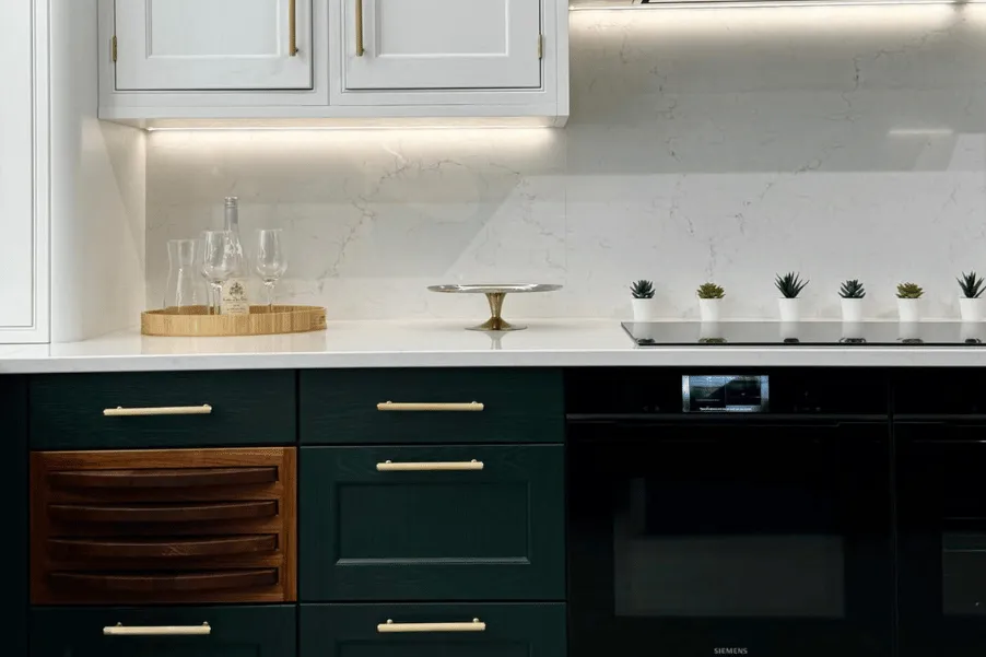 dark green and white kitchen display with gold handles and veined worktop in Gardiner Haskins Kitchen Showroom in Bristol