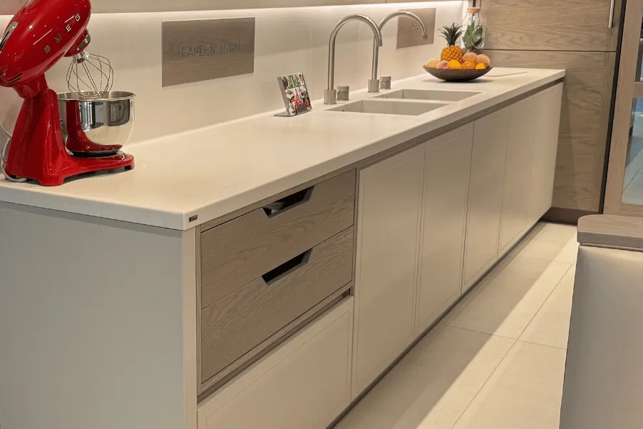Stoneham contemporary kitchen display with handleless doors and red baking mixer on worktops