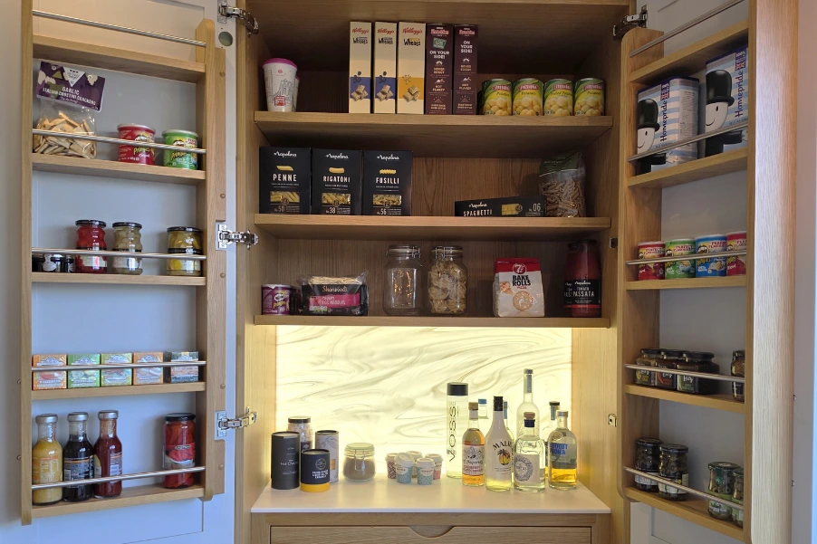 Inside a pantry cupboard with wooden shelves and spice racks