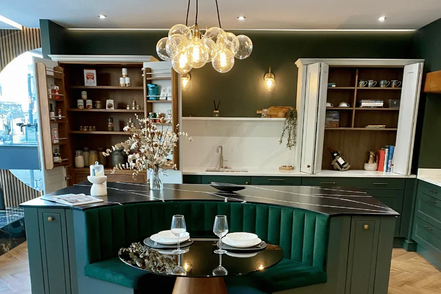 Dark green kitchen island booth and white counter-top storage cabinets