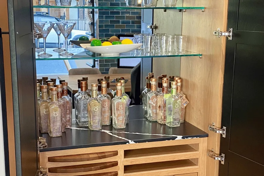 interior of a pantry bar with glass shelving and worktop area