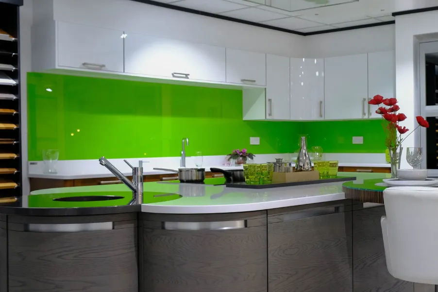 Bright green kitchen splashback under white gloss cabinets