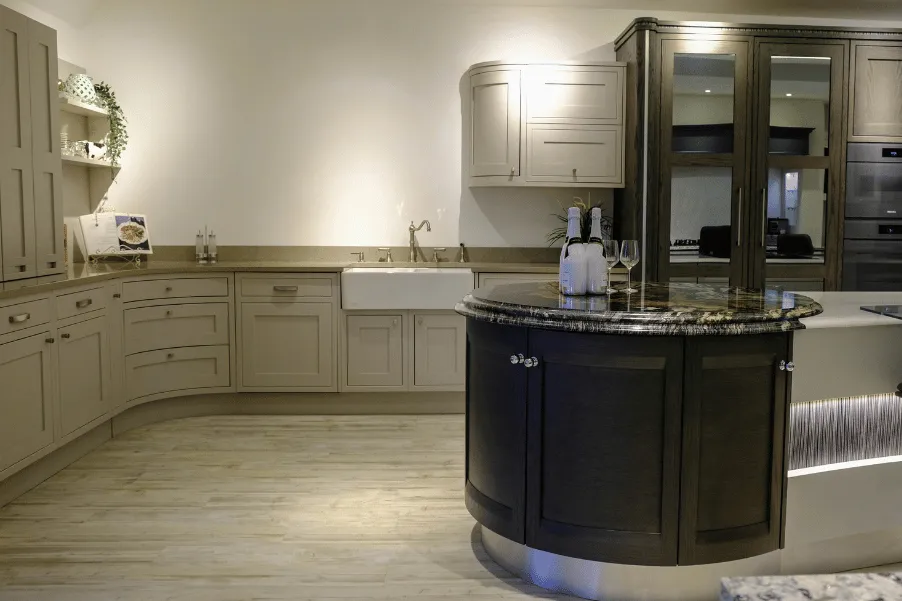 Curved cream classic cabinetry and wooden curved corner on kitchen island