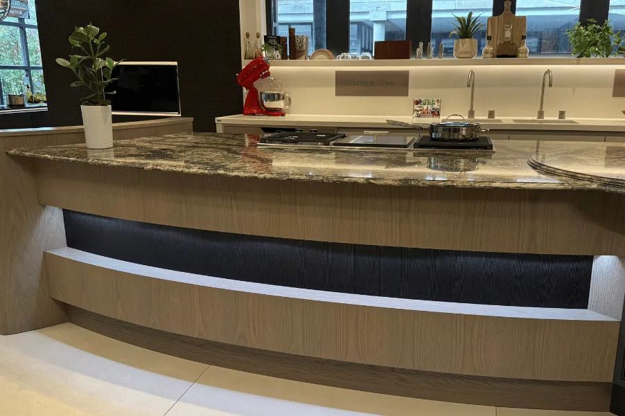 Panel on side of kitchen island with curved dark veined worktop