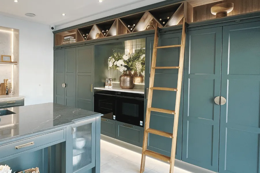ladder rail system on tall green kitchen cabinets