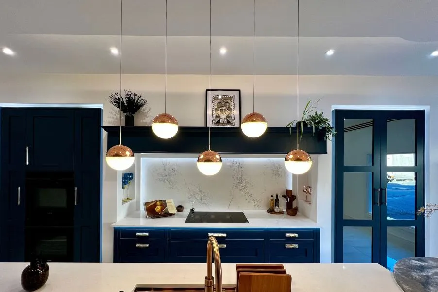 Pendant lighting over island with hob and mantle area