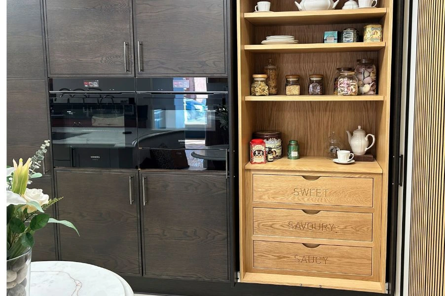 wooden pantry cupboard with engraved drawers