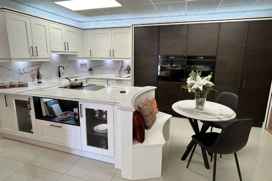 white classic kitchen with integrated booth and tall wooden contemporary doors